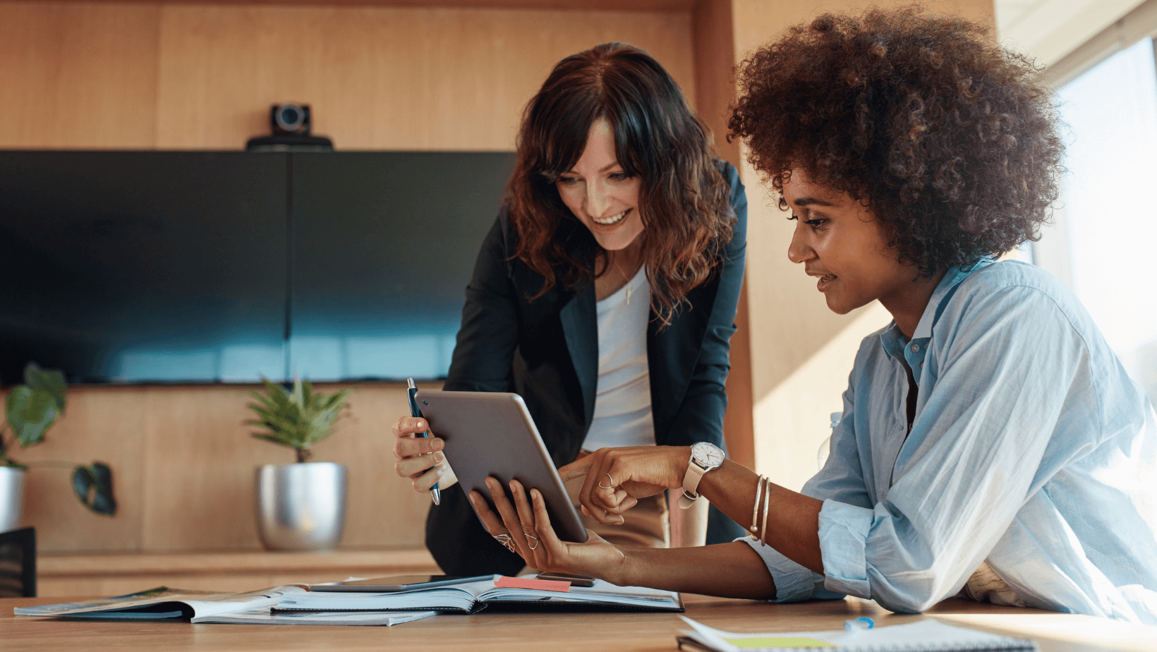Two women viewing hr tech tools on ipad