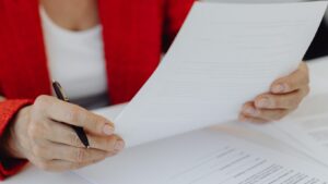 Close-up of a professional reviewing a written document and taking notes during a workplace investigation.