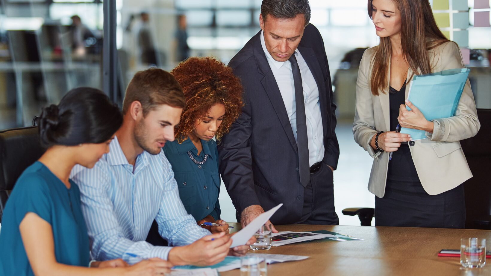 Business professionals reviewing workplace investigation documents during a compliance meeting