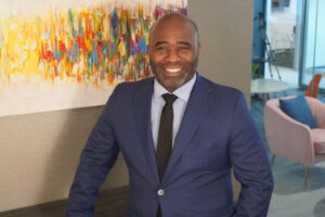 Travis Foster standing in a professional office environment discussing employee reporting and workplace investigation processes
