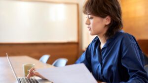 HR professional reviewing investigation documents at a laptop